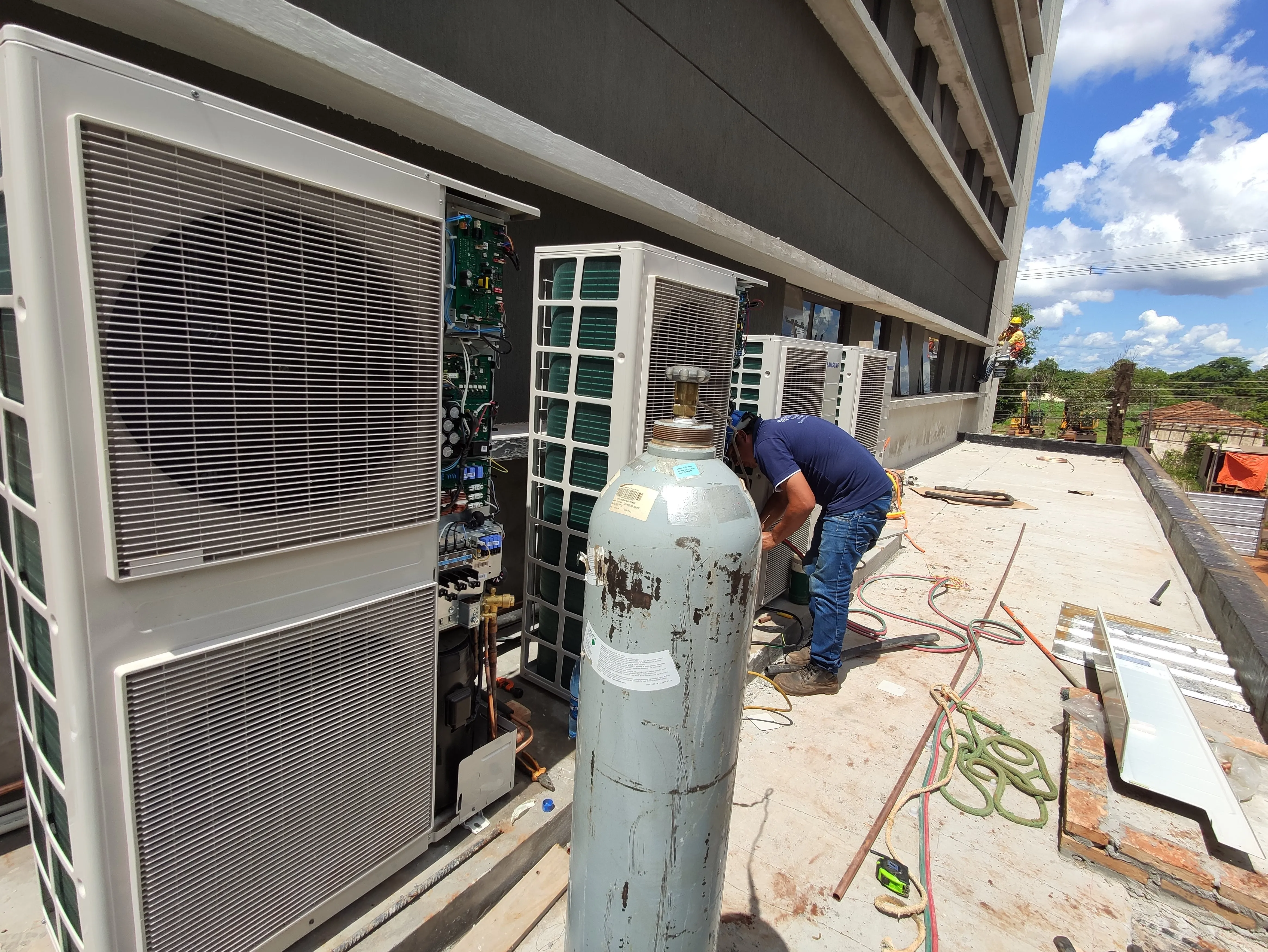 Técnico de Electrofrío trabajando sobre un banco de condensadoras VRF instalado en la azotea de un edificio.