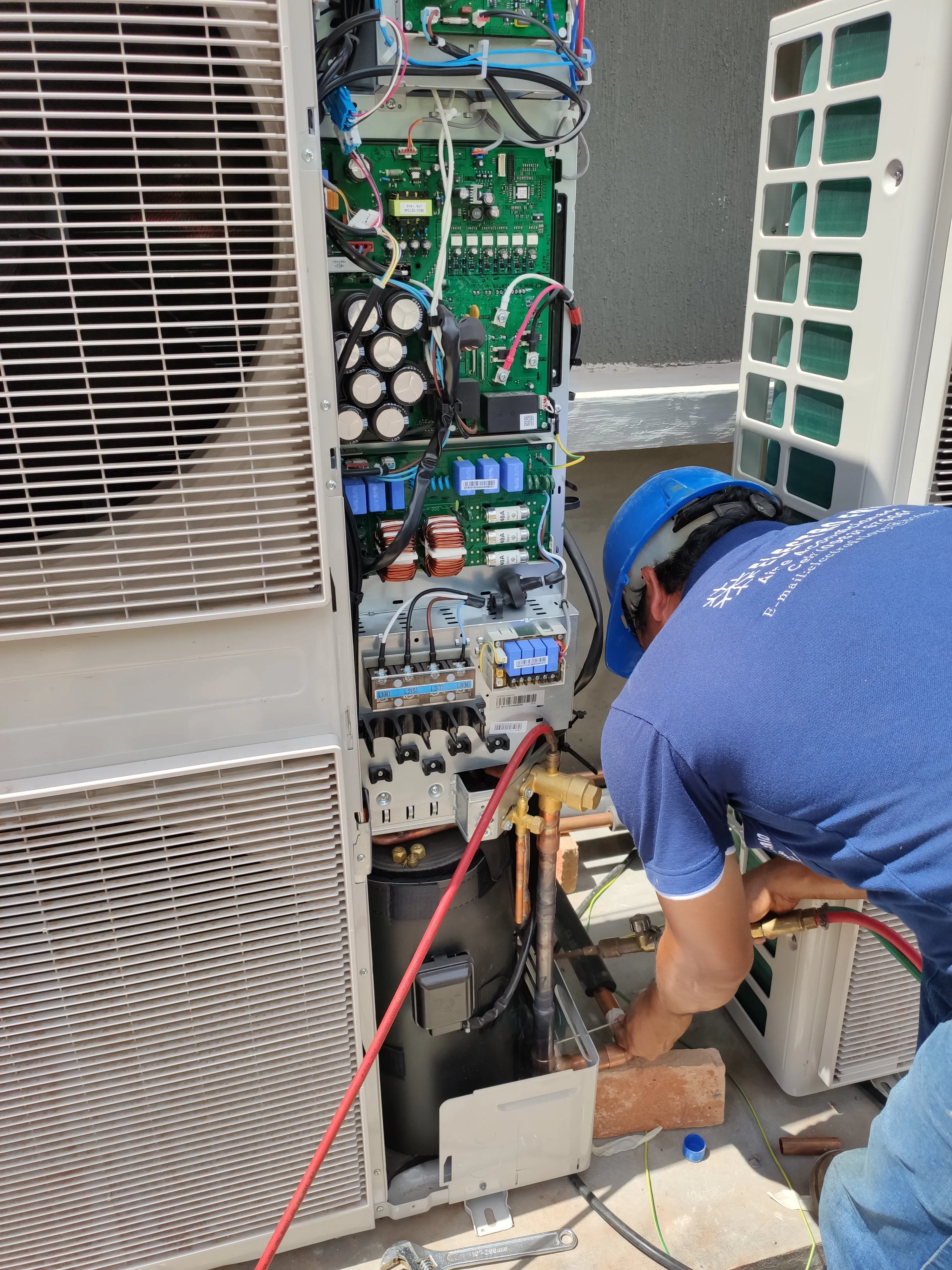 Técnico de Electrofrío revisando la placa de control y el cableado de una unidad exterior.